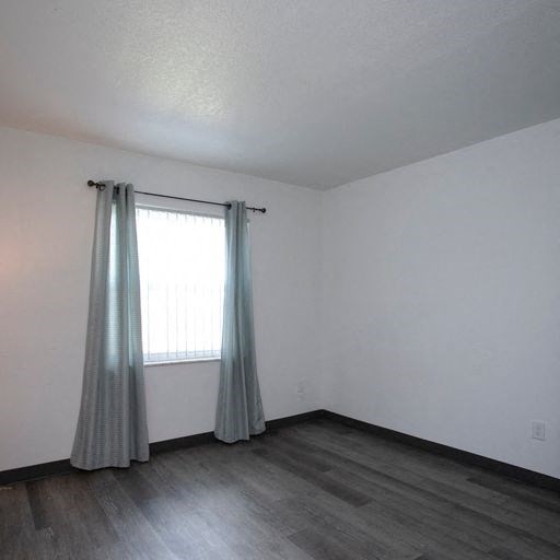 an empty room with a window and a curtain