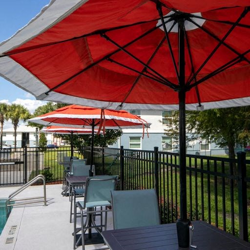 a patio with umbrellas and tables with chairs