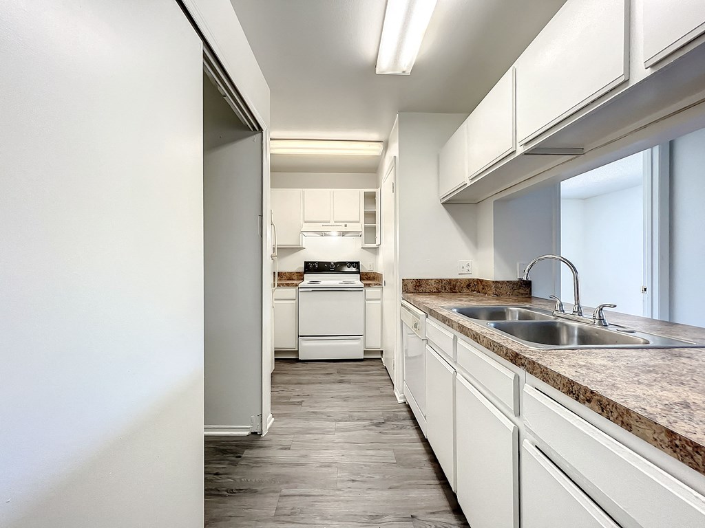 a kitchen with white cabinets and a white stove top oven