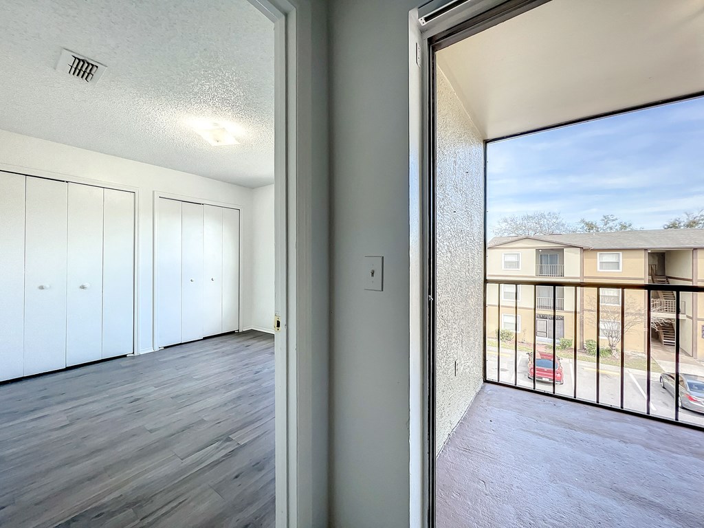 a bedroom with a large window and a balcony