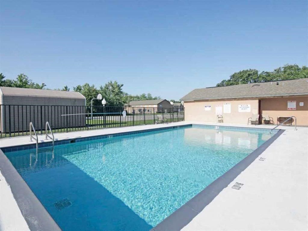 a pool with a fence around it next to a building
