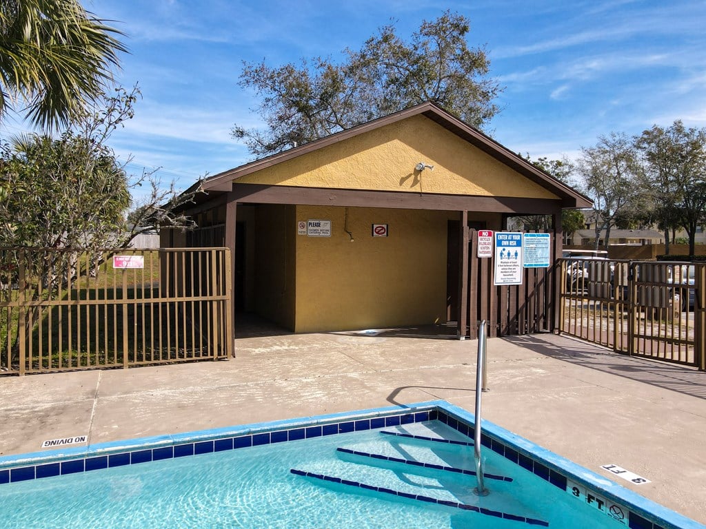 a small building with a pool in front of it