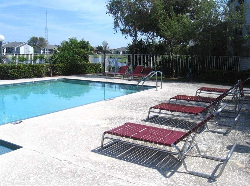 a swimming pool with red chairs next to it