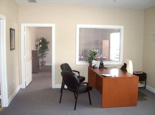 a room with a desk and a chair and a window