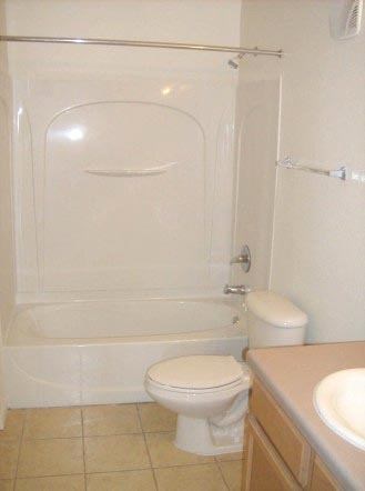 a white bathroom with a toilet and a shower