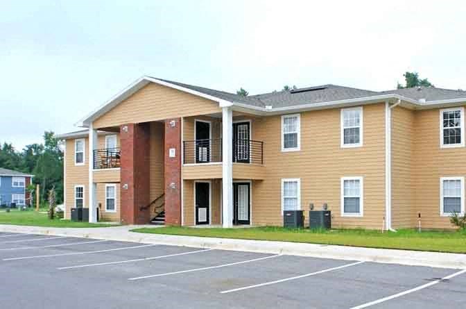 a large apartment building in a parking lot