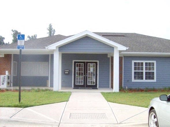 a blue house with a car parked in a driveway