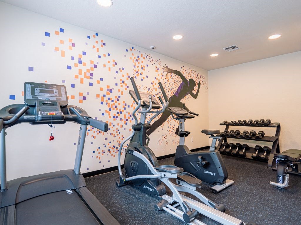 a gym with exercise equipment and wall art