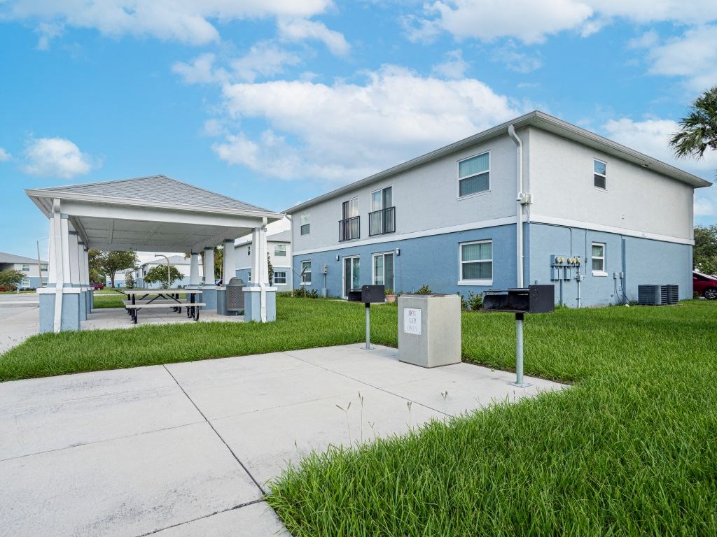a white and blue house with a driveway and a covered porch
