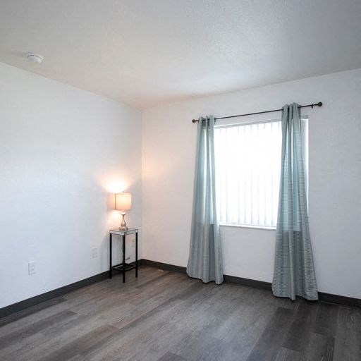 an empty room with a window and curtains