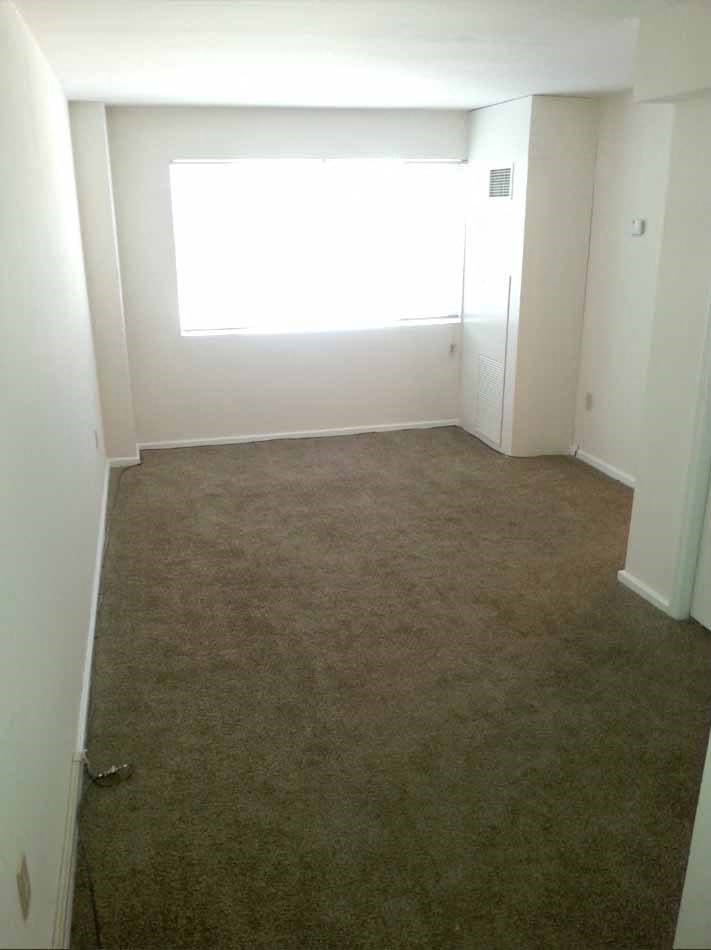 an empty room with carpet and a window