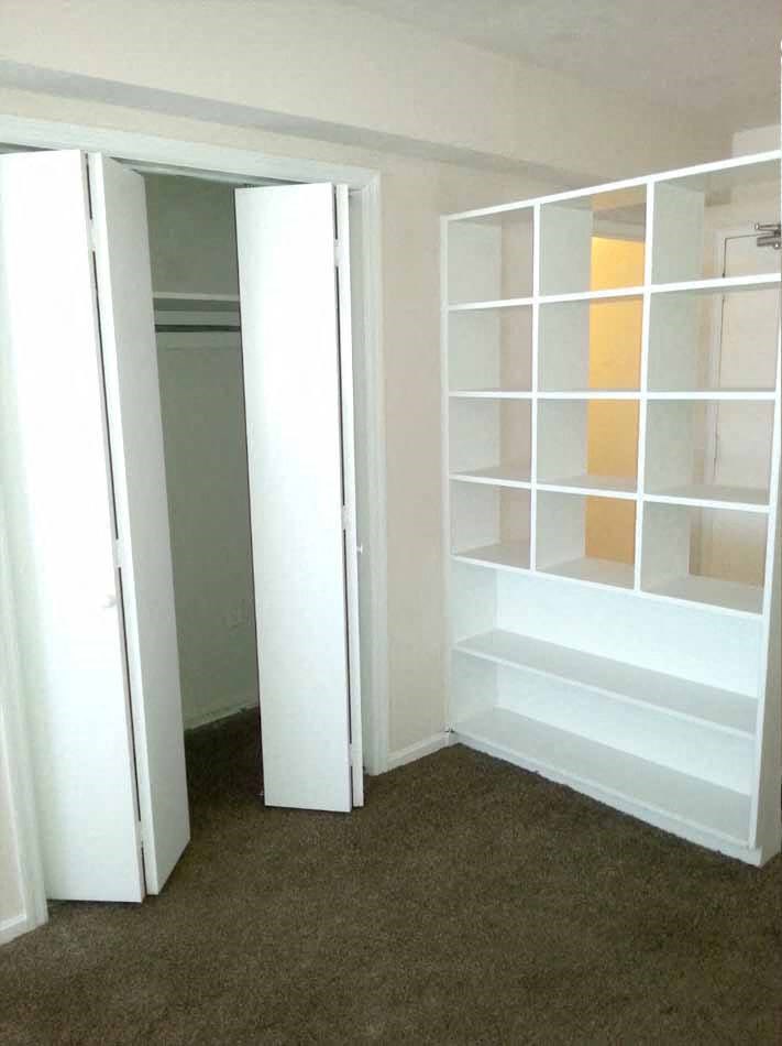 a closet with white shelves and a closet door