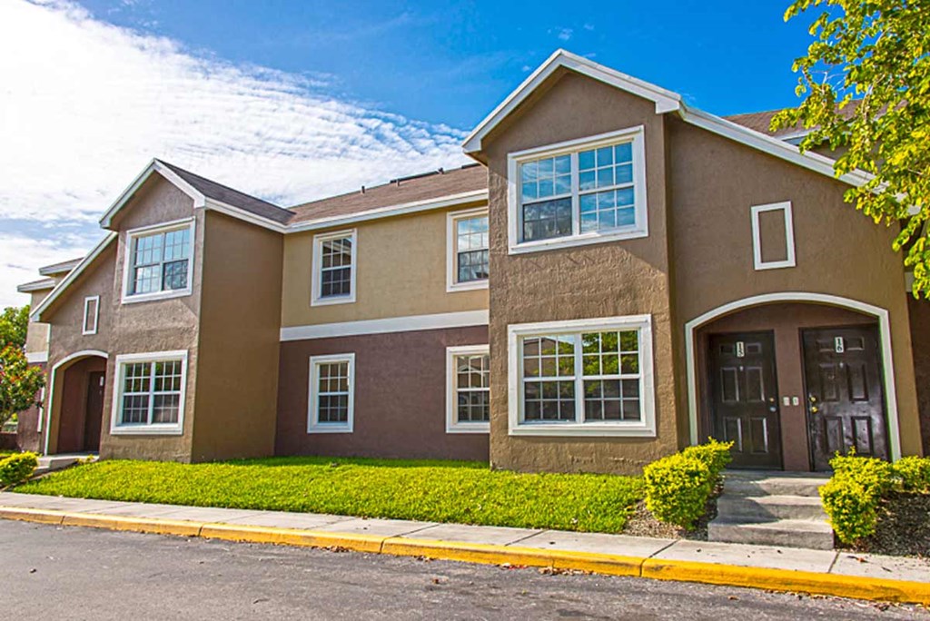 a brown house with a sidewalk in front of it