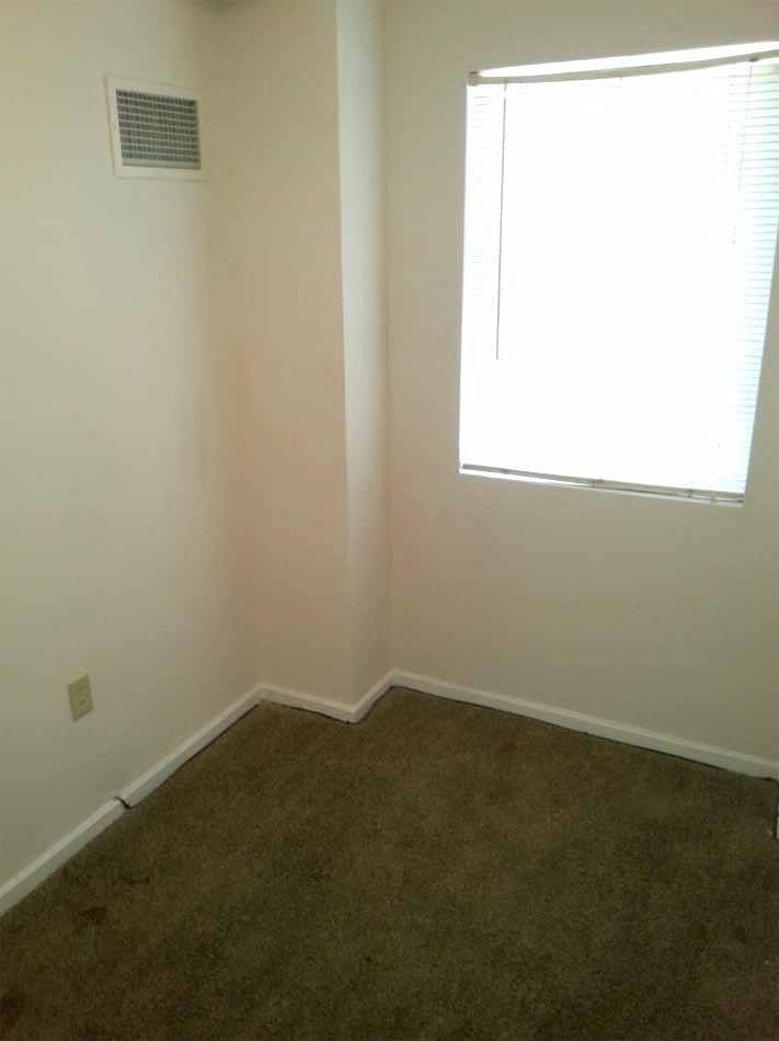 an empty room with a window and a carpet