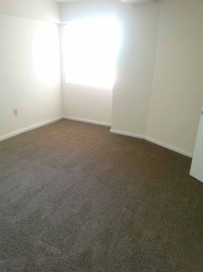 an empty room with carpet and a window