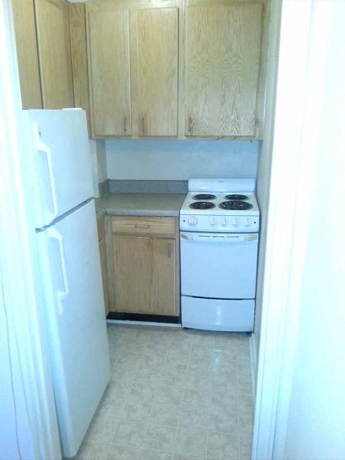 a small kitchen with a white stove and refrigerator