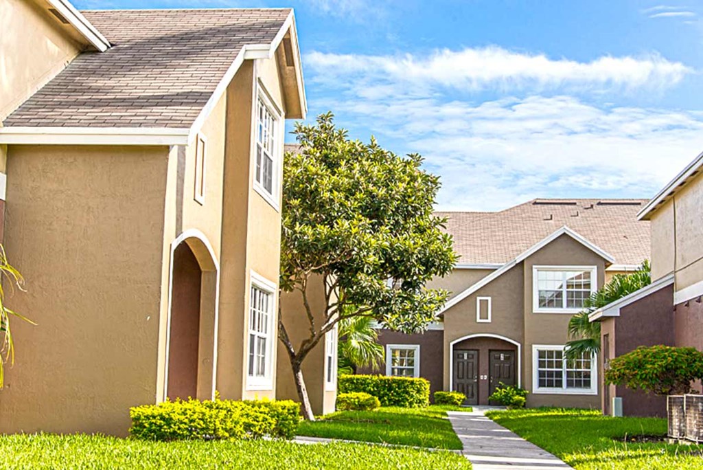 a row of houses with a sidewalk in front of them