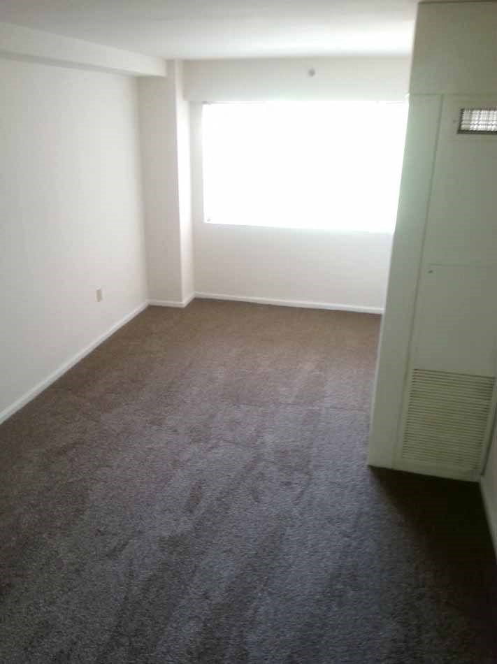 an empty room with a closet and a window