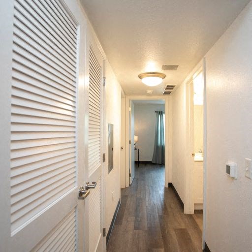 a hallway with white walls and a wood floor