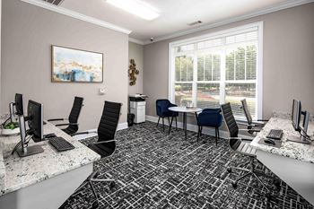 a conference room with desks and chairs and a window  at Abberly Green Apartment Homes by HHHunt, Mooresville, NC 28117