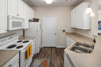 a kitchen with white appliances and white cabinets at Abberly Green Apartment Homes by HHHunt, Mooresville, NC 28117