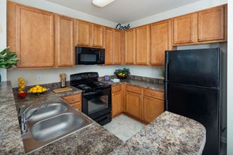 Kitchen With Sink, Refrigerator And Modern Appliances Kitchen With Sink, Refrigerator And Modern Appliances at Abberly Village Apartment Homes by HHHunt, South Carolina, 29169