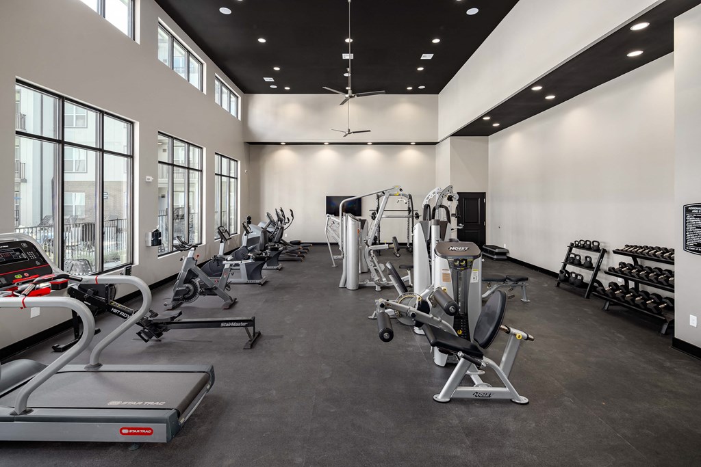 a spacious fitness center with cardio machines and weights