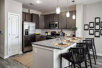 a kitchen with a large island with granite countertops