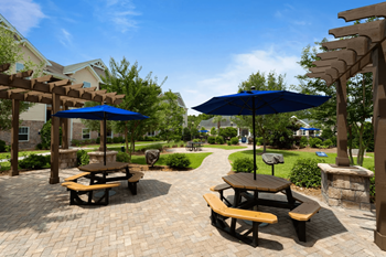 an outdoor patio with picnic tables and umbrellas