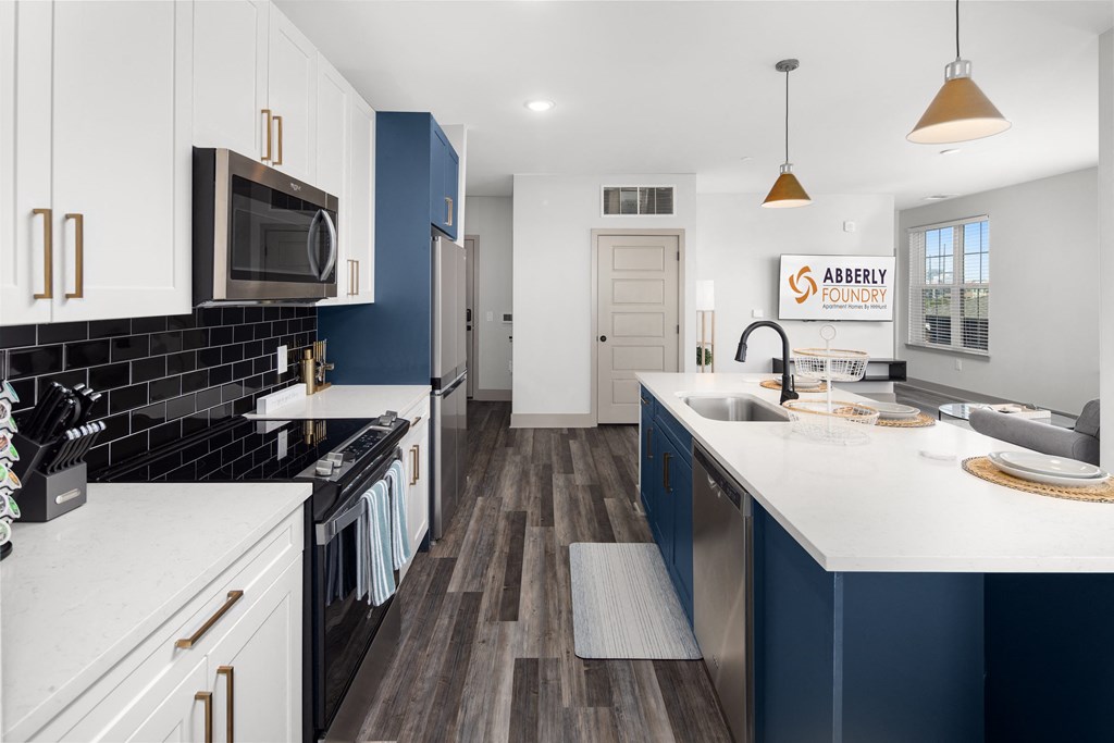 a kitchen with white countertops and blue cabinetsat Abberly Foundry Apartment Homes, Nashville