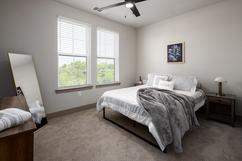 a bedroom with a bed and two windowsat Abberly Foundry Apartment Homes, Nashville, TN, 37206