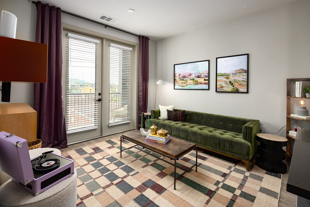a living room with a green couch and purple curtains at Abberly Foundry Apartment Homes, Nashville