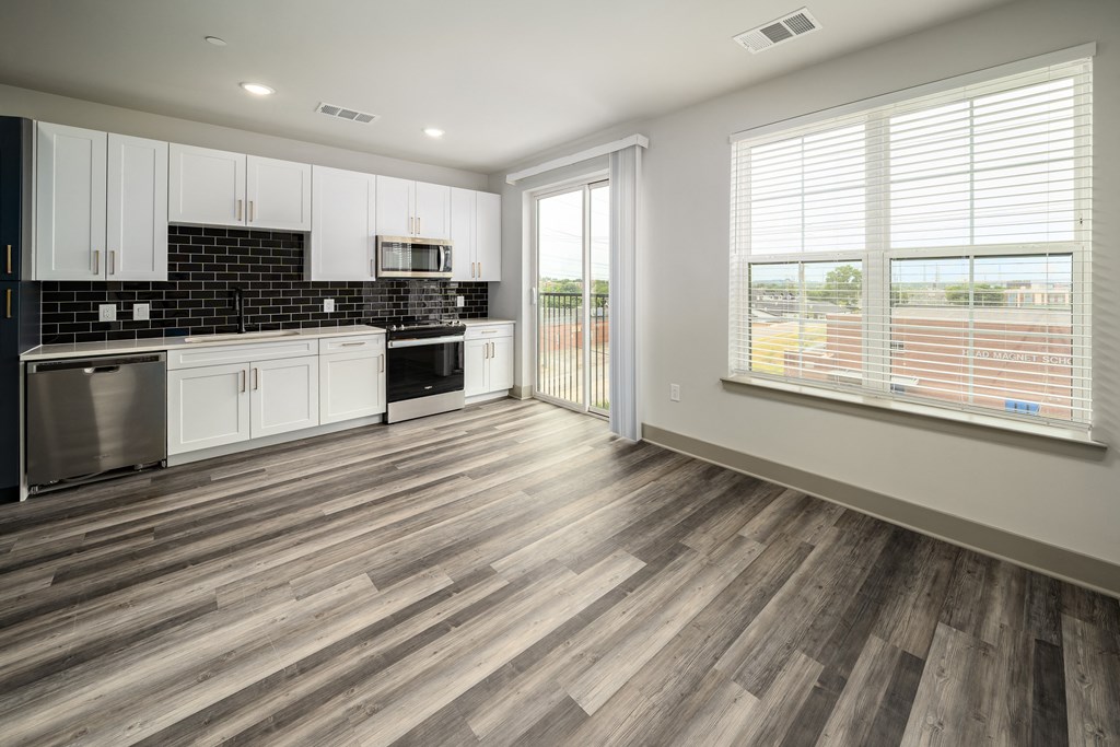 a kitchen with white cabinets and black and white appliances at Abberly Foundry Apartment Homes, Nashville