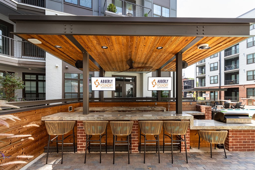 a patio with a bar and a pool in front of a building at Abberly Foundry Apartment Homes, Nashville, Tennessee
