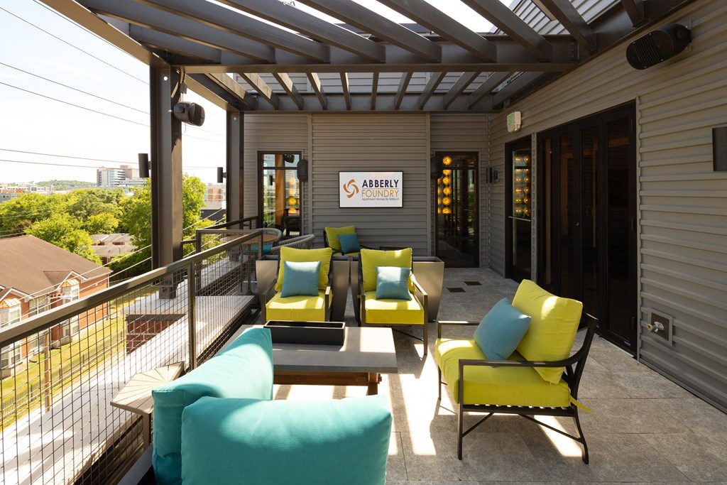 a patio with yellow and blue couches and chairs at Abberly Foundry Apartment Homes, Nashville, TN
