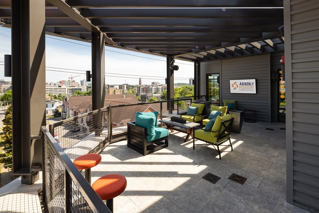 a patio with chairs and a table on top of a buildingat Abberly Foundry Apartment Homes, Nashville, TN