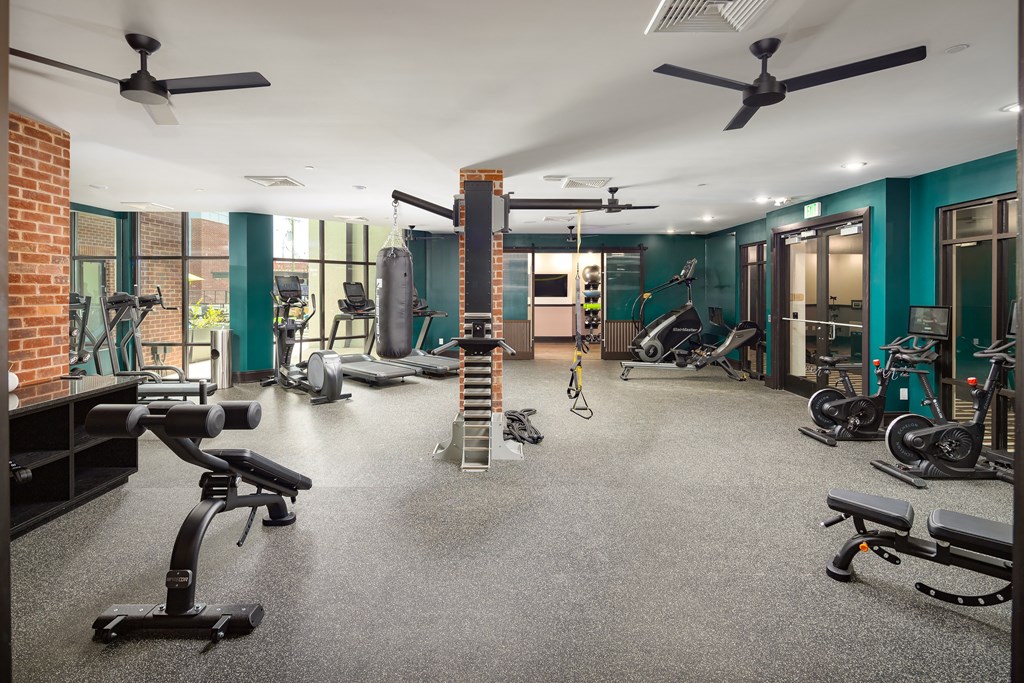 a large fitness room with exercise equipment and green wallsat Abberly Foundry Apartment Homes, Nashville, TN