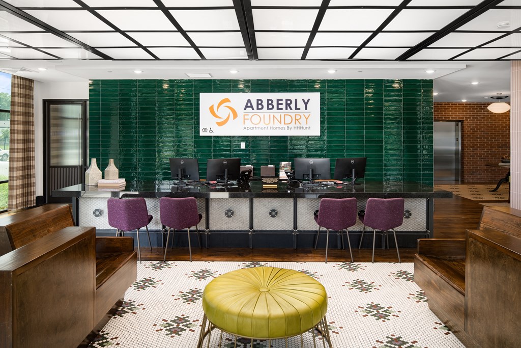 a view of the abbey foundry reception desk with purple and green chairs and a yellowat Abberly Foundry Apartment Homes, Nashville