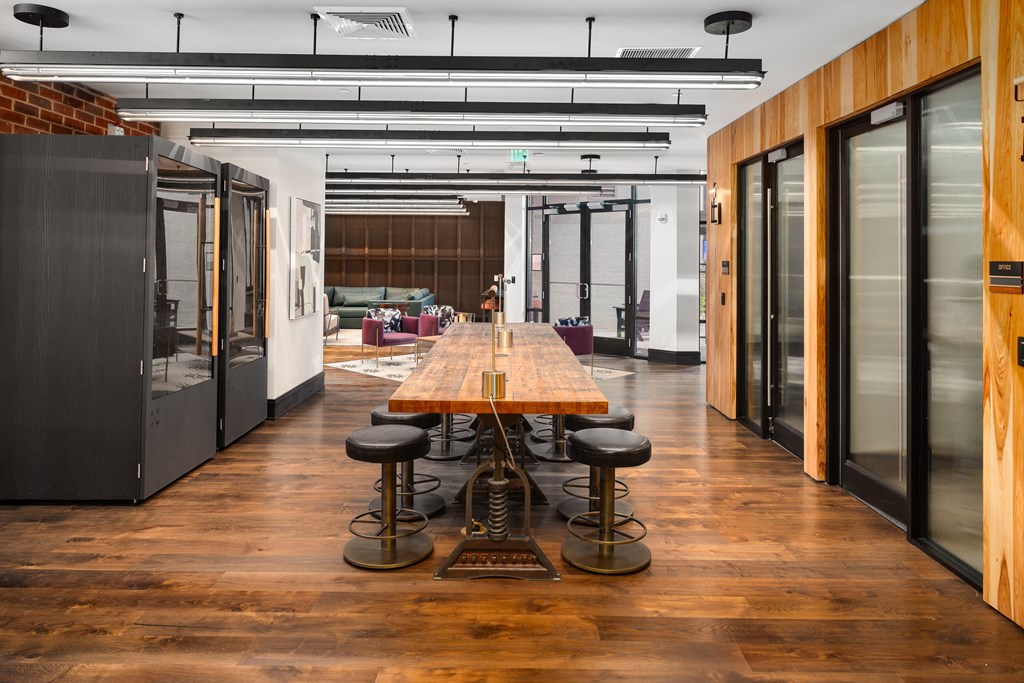 a conference room with a long wooden table and black stools at Abberly Foundry Apartment Homes, Nashville, TN