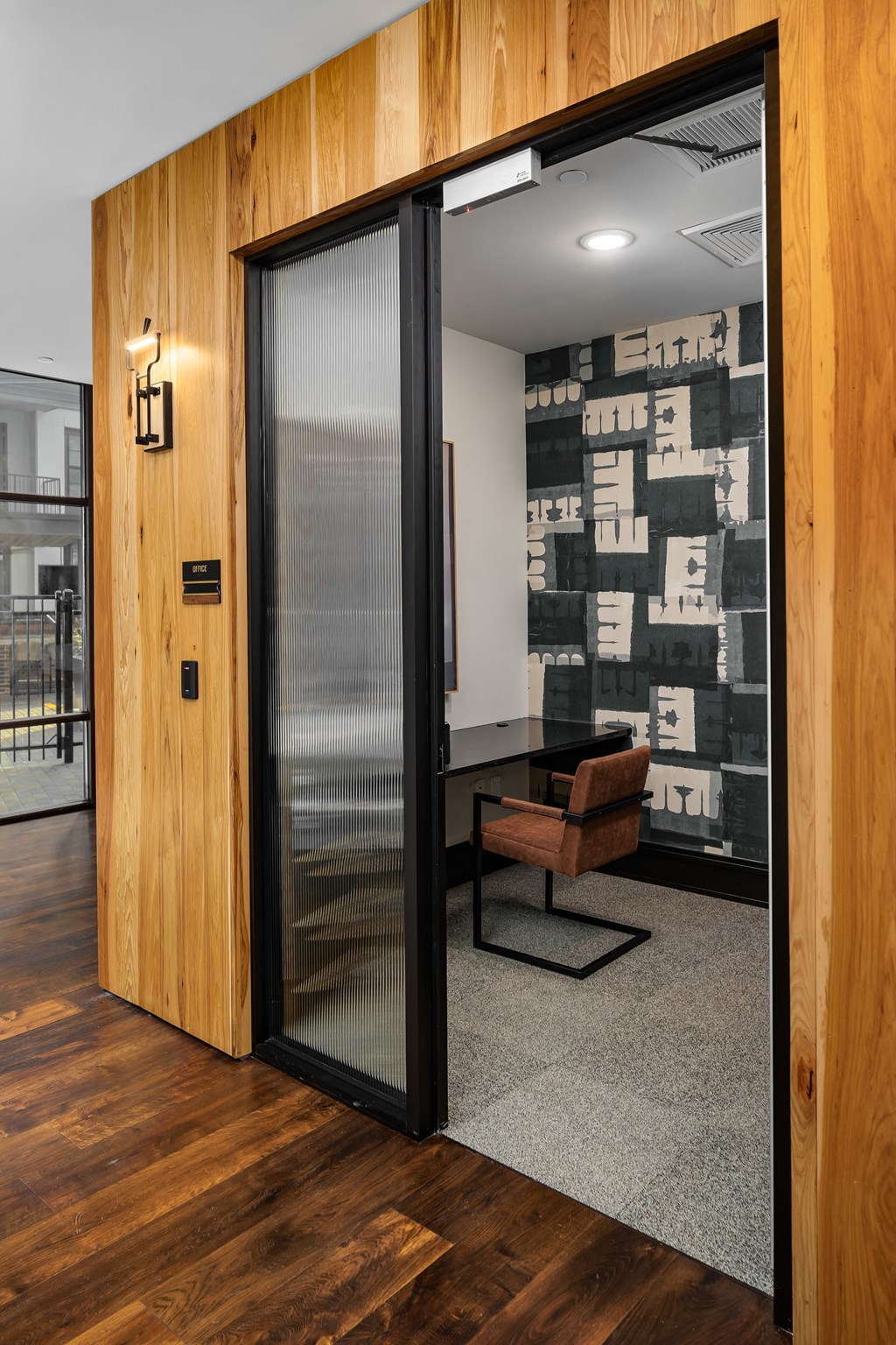 a meeting room with a wooden wall and a glass door at Abberly Foundry Apartment Homes, Nashville, TN, 37206