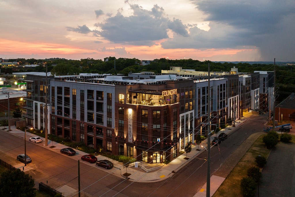 an aerial view of a large building with a sunset in the background at Abberly Foundry Apartment Homes, Nashville, TN