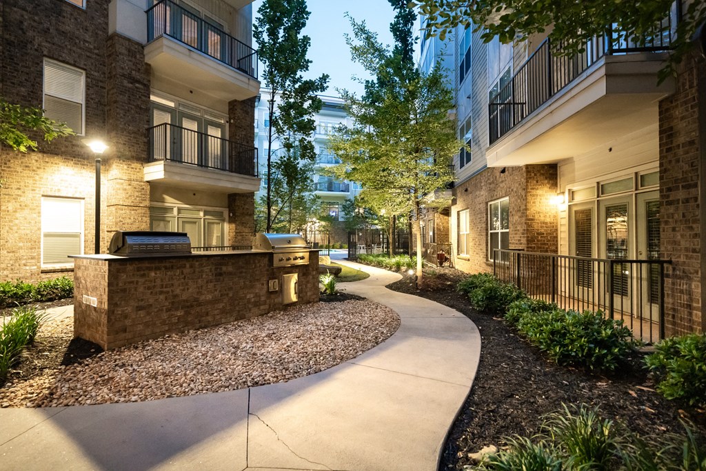 a pathway leading to an apartment complex with trees and bushes  at Abberly Onyx Apartment Homes, Decatur, GA