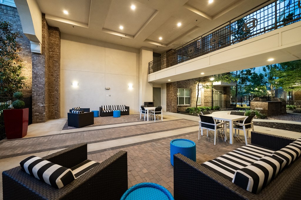 a lounge area with tables and chairs and a fire pit in the background  at Abberly Onyx Apartment Homes, Decatur, 30033