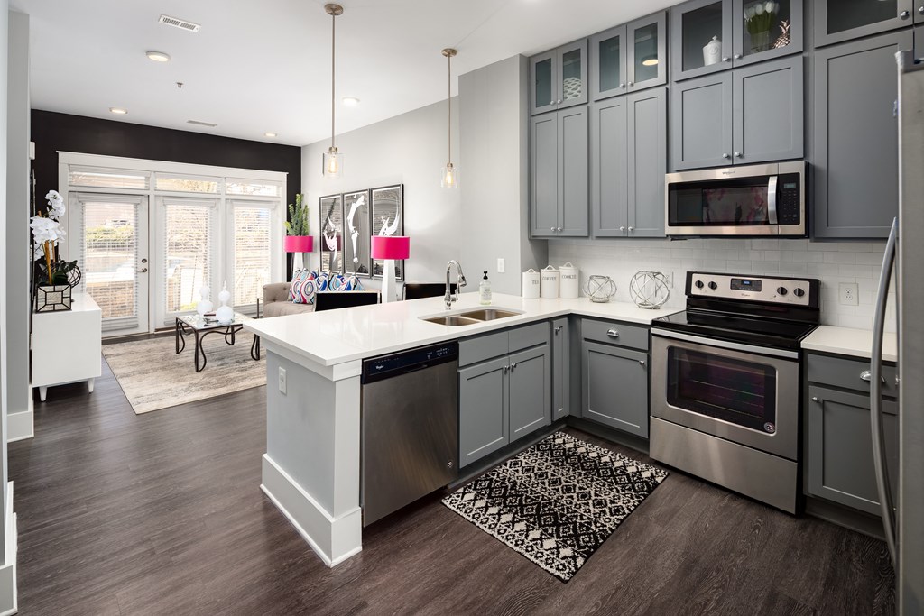 a kitchen with gray cabinets and a white counter top