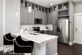 a kitchen with a white counter top and a stainless steel refrigerator at Abberly Onyx Apartment Homes, Decatur, 30033