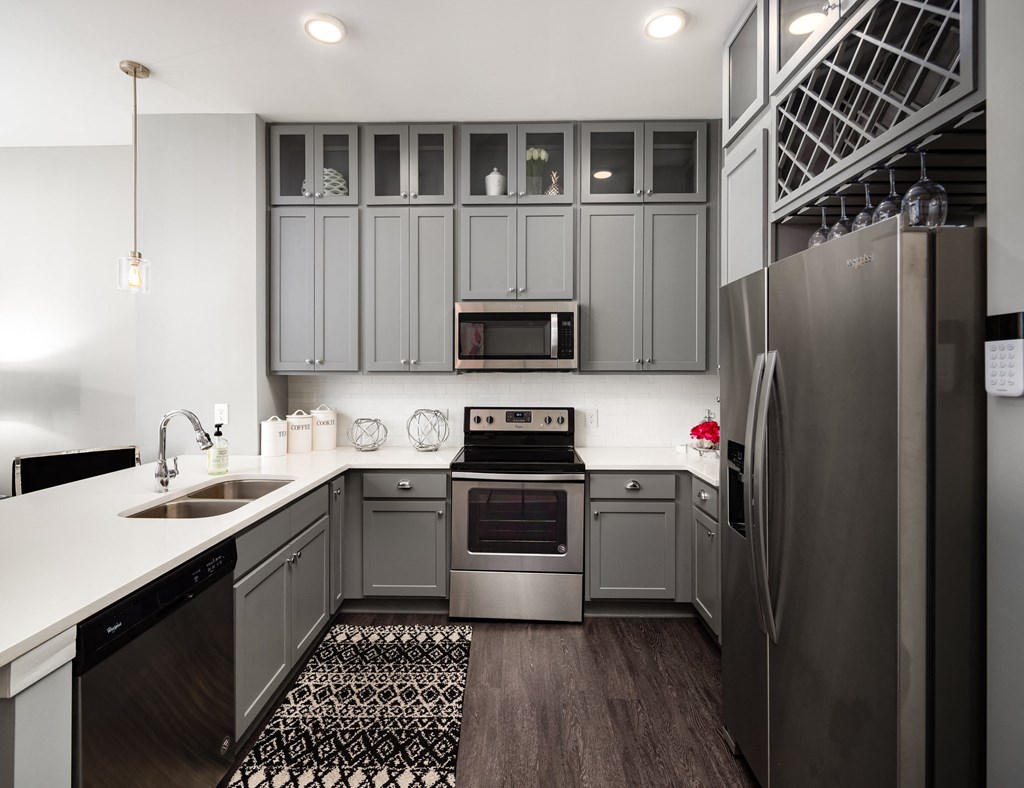 a kitchen with gray cabinets and stainless steel appliances