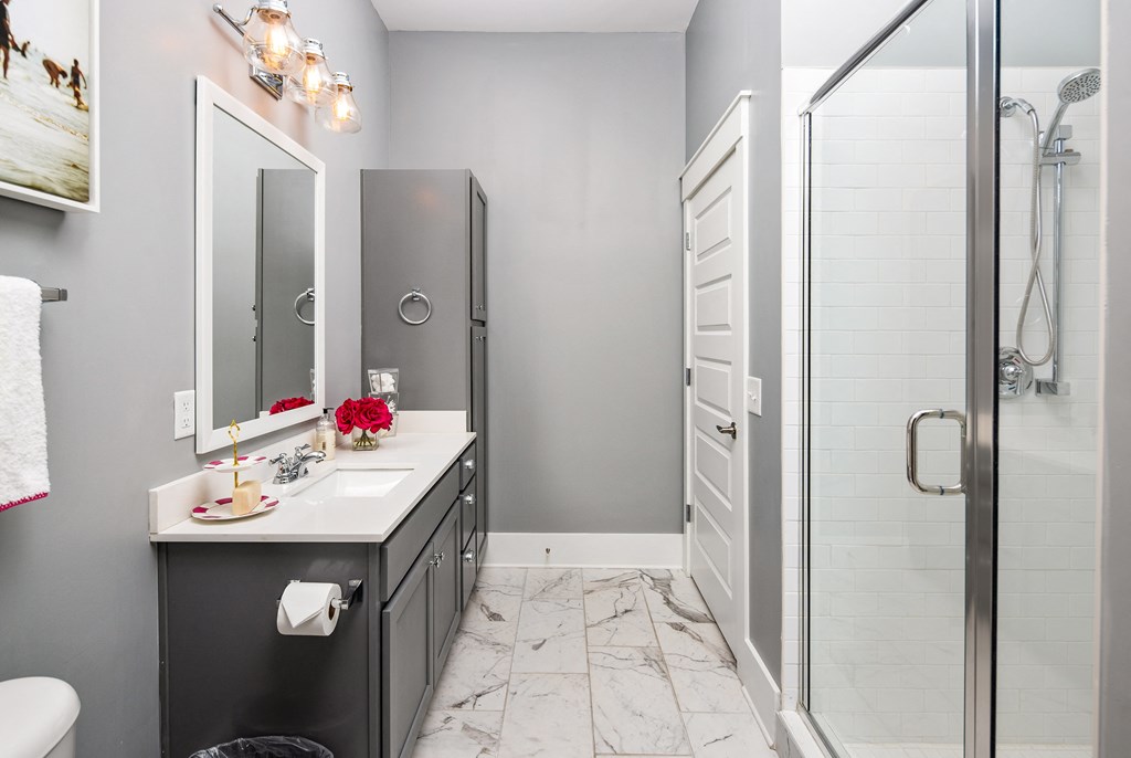 a bathroom with a shower and a sink and a mirror