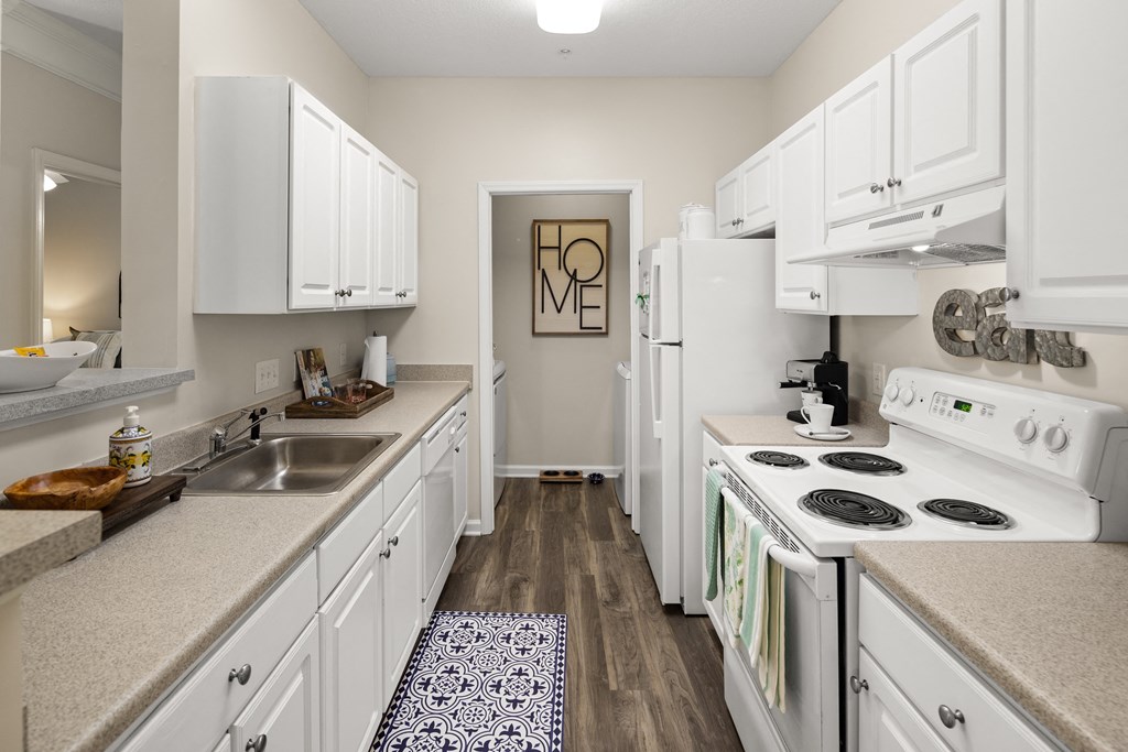 a kitchen with white cabinets and a white stove top oven  at Abberly Grove Apartment Homes, Raleigh, NC