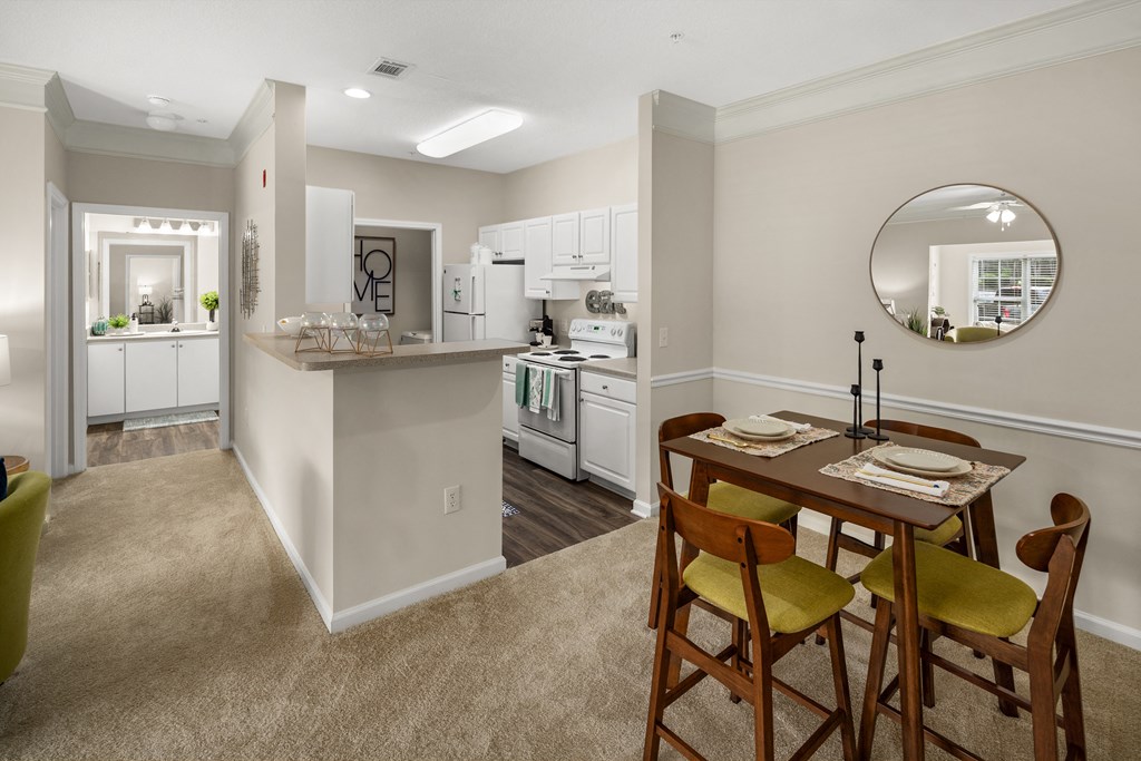 a dining area with a table and chairs and a kitchen in the background at Abberly Grove Apartment Homes, Raleigh, 27610