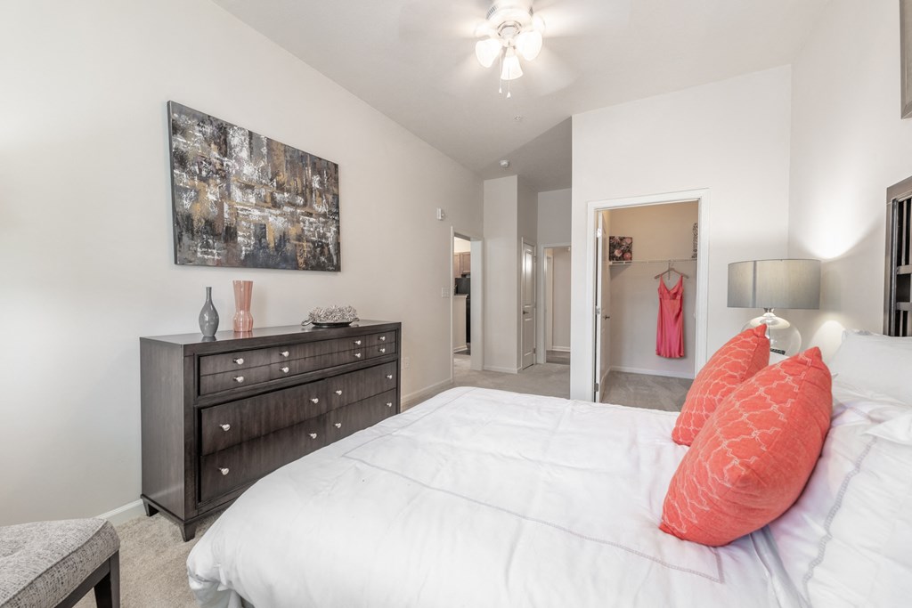 a bedroom with a large bed and a dresser at Abberly Crest Apartment Homes, Lexington Park, MD